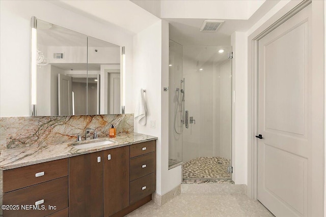 bathroom with a stall shower, vanity, visible vents, and decorative backsplash