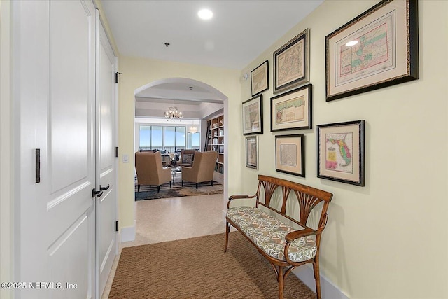 corridor featuring arched walkways, recessed lighting, and a notable chandelier