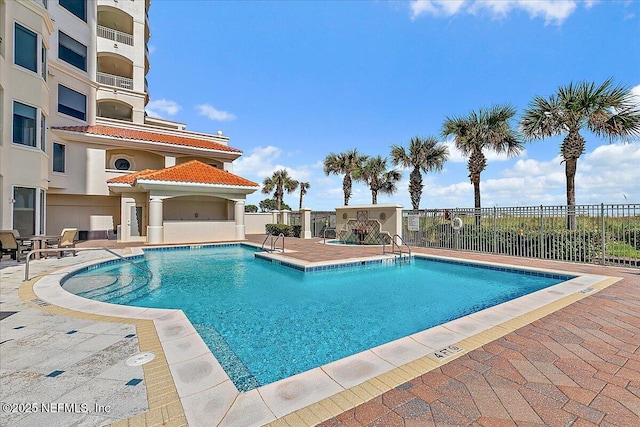 pool with a patio and fence