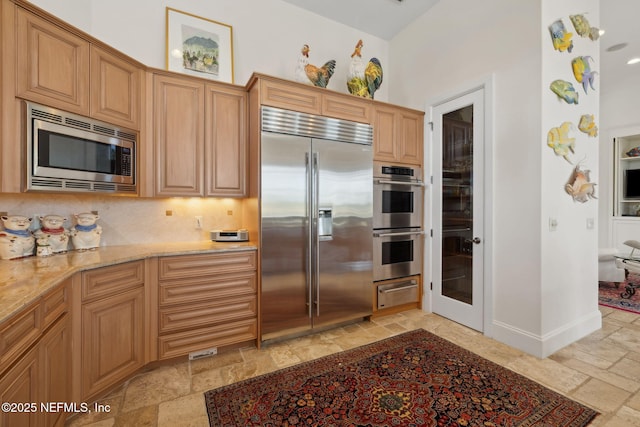 236 Deer Haven Dr, Ponte Vedra Beach, FL 32082 - kitchen featuring built in appliances, stone tile floors, a warming drawer, light stone countertops, and baseboards