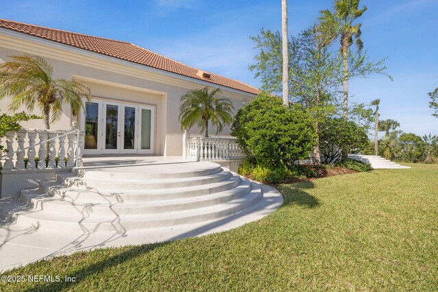 236 Deer Haven Dr, Ponte Vedra Beach, FL 32082 - rear view of house featuring french doors, a tiled roof, a yard, and stucco siding
