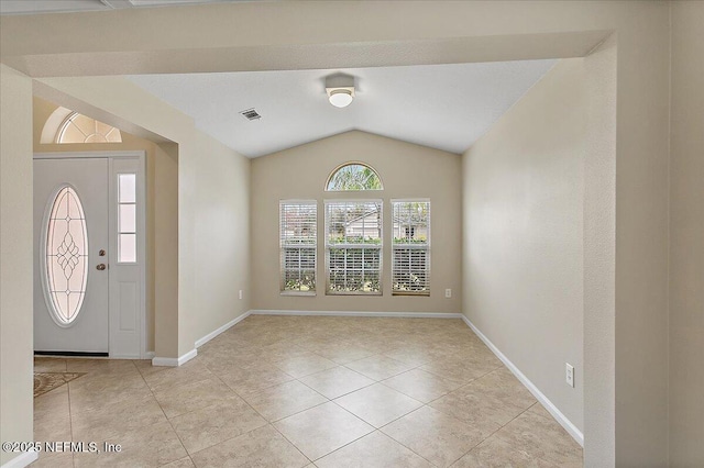 entrance foyer with vaulted ceiling, light tile patterned floors, visible vents, and baseboards