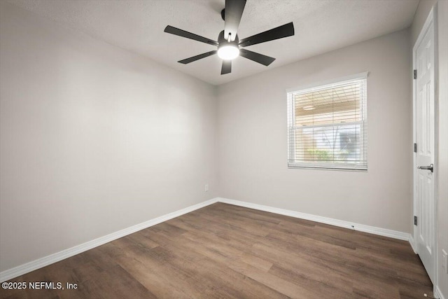 empty room with ceiling fan, baseboards, and dark wood finished floors