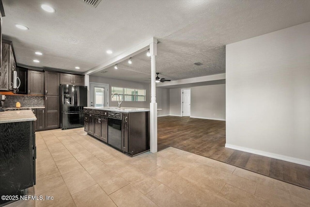 kitchen with black appliances, ceiling fan, light countertops, and a textured ceiling