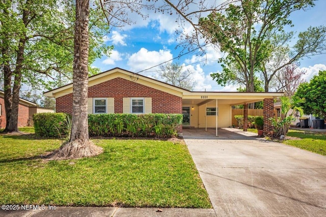 ranch-style home with driveway, a front yard, an attached carport, and brick siding