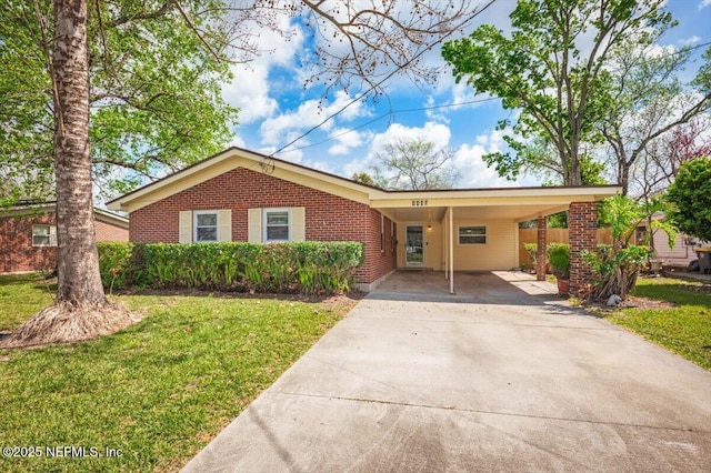 ranch-style home with a carport, driveway, brick siding, and a front yard