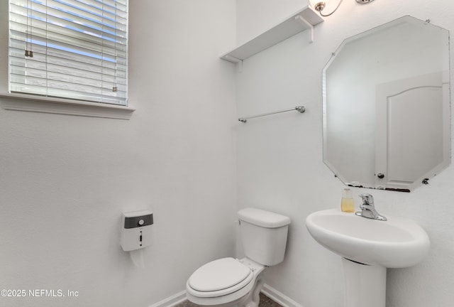 half bath with toilet and baseboards