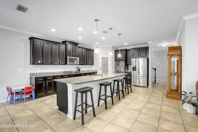 kitchen with an island with sink, visible vents, appliances with stainless steel finishes, and a sink