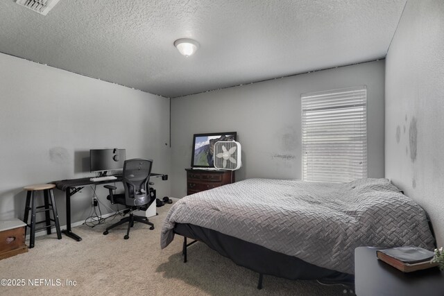 carpeted bedroom featuring visible vents and a textured ceiling
