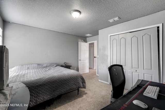 carpeted bedroom with a closet, visible vents, and a textured ceiling