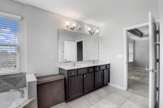 bathroom with double vanity, tile patterned flooring, a textured ceiling, and a sink