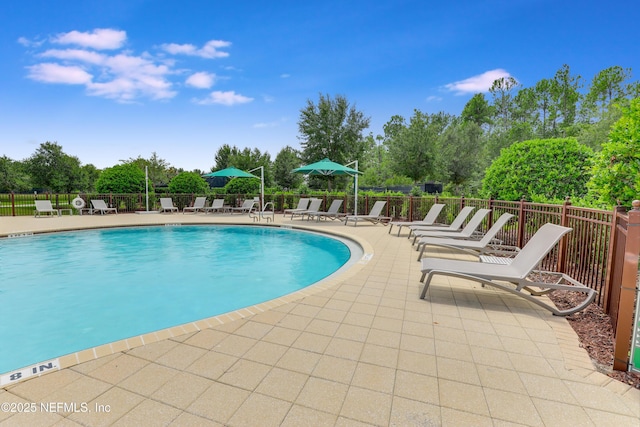 pool featuring a patio and fence