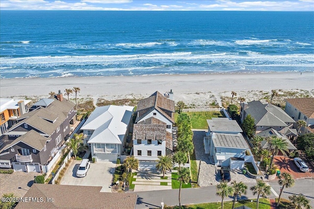 drone / aerial view with a residential view, a water view, and a beach view