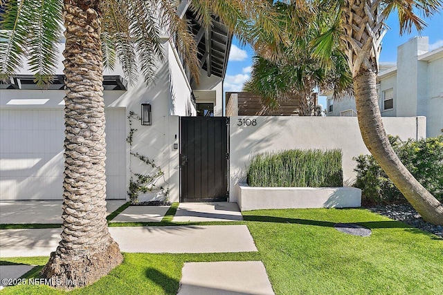 view of gate featuring a lawn and fence