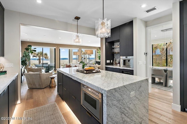 kitchen with light wood finished floors, modern cabinets, and dark cabinets