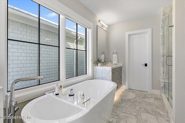 bathroom with marble finish floor, a freestanding bath, a shower stall, and vanity