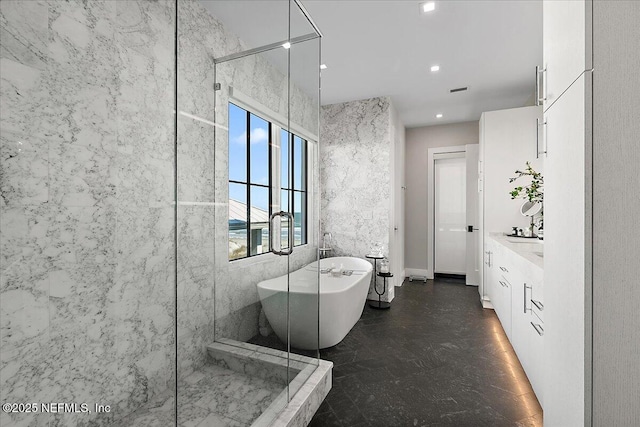 full bathroom with tile walls, recessed lighting, a stall shower, vanity, and a freestanding tub