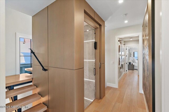 hallway with baseboards and light wood finished floors