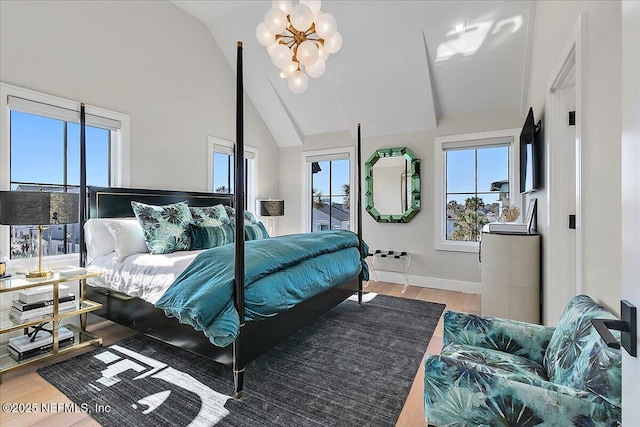 bedroom with baseboards, high vaulted ceiling, wood finished floors, and a notable chandelier