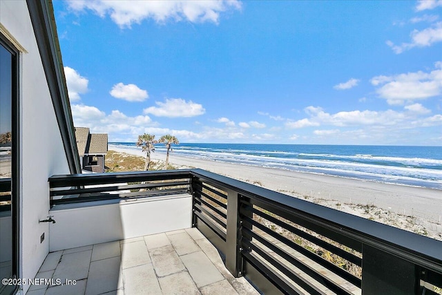 balcony with a beach view and a water view