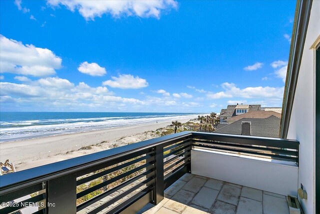 balcony featuring a view of the beach and a water view