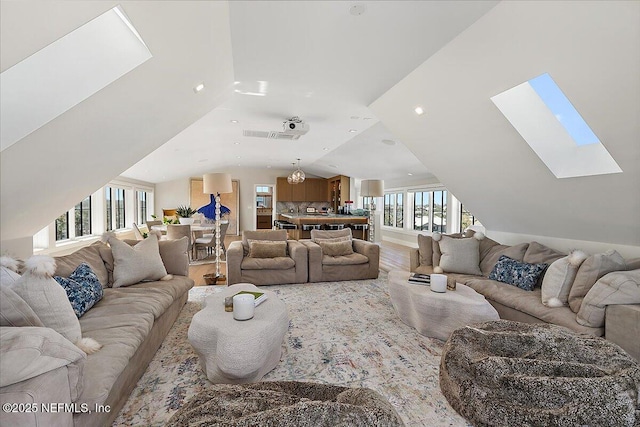 living area with lofted ceiling with skylight, recessed lighting, and wood finished floors