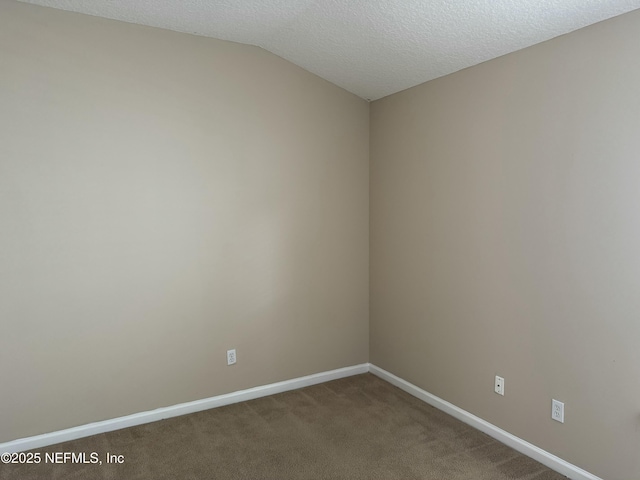 unfurnished room with lofted ceiling, carpet flooring, a textured ceiling, and baseboards