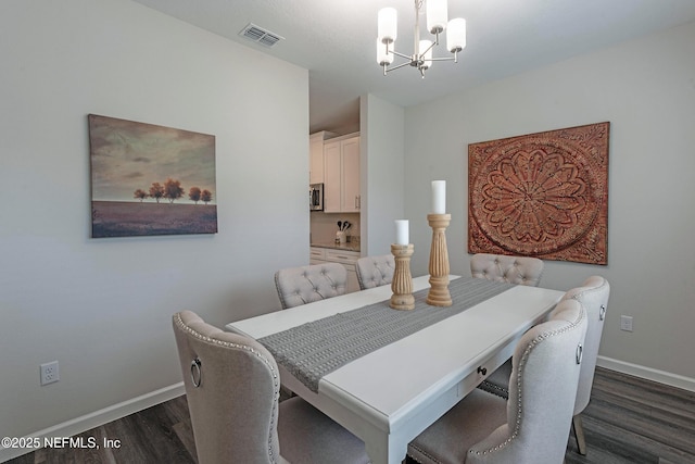 dining area with baseboards, dark wood-type flooring, visible vents, and a notable chandelier