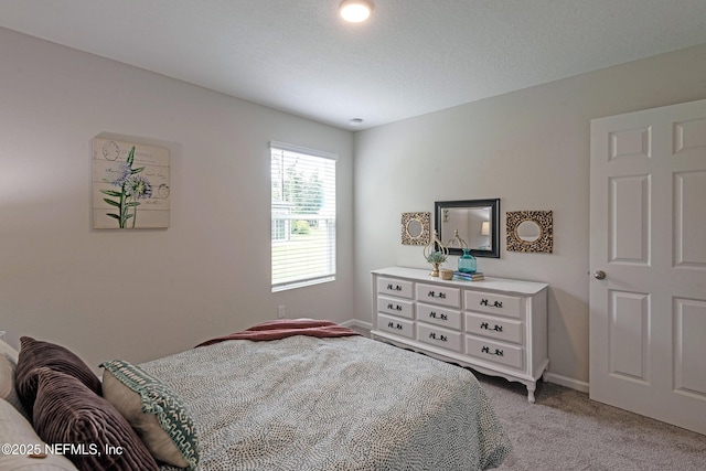 bedroom with baseboards and light colored carpet