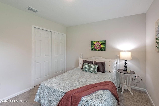 bedroom with carpet floors, a closet, visible vents, and baseboards