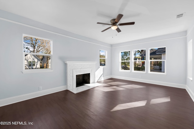 unfurnished living room featuring visible vents, a fireplace, baseboards, and wood finished floors