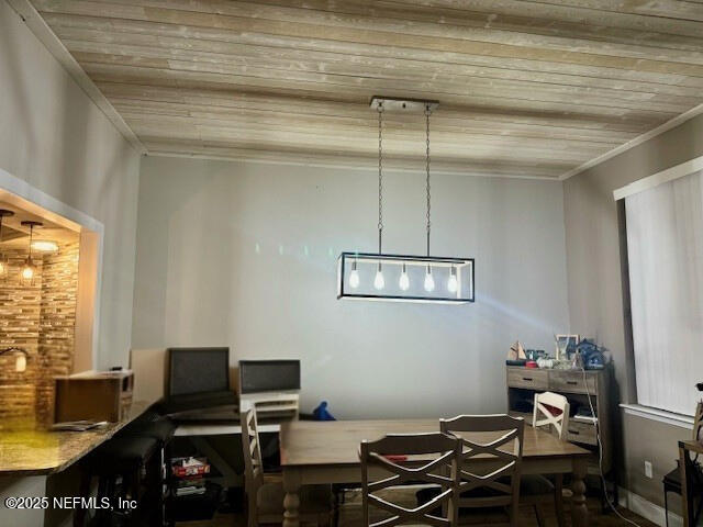 dining space featuring wooden ceiling and crown molding