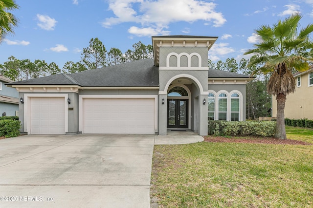 view of front of home featuring french doors, stucco siding, a garage, driveway, and a front lawn