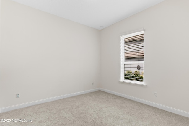 carpeted empty room featuring baseboards