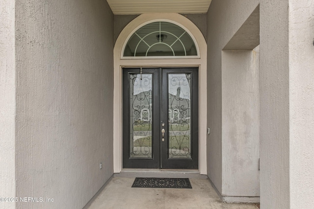 doorway to property featuring french doors and stucco siding