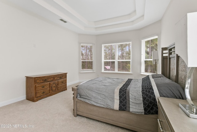 bedroom featuring carpet, a raised ceiling, visible vents, and baseboards