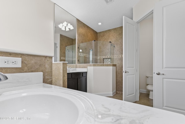 full bath with a garden tub, tile walls, toilet, vanity, and tiled shower