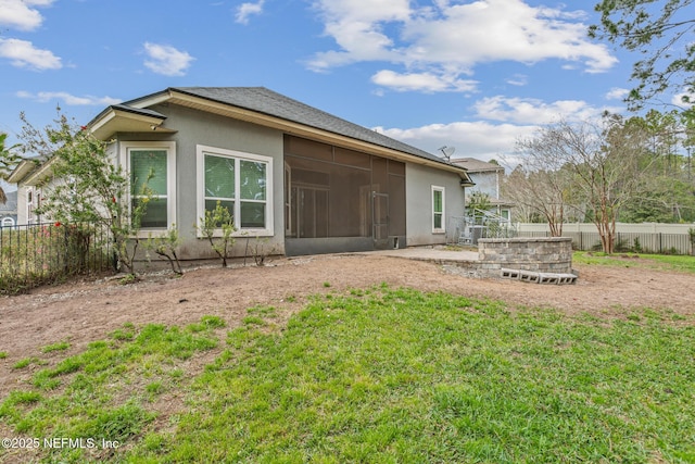 back of property featuring a sunroom, a fenced backyard, and stucco siding