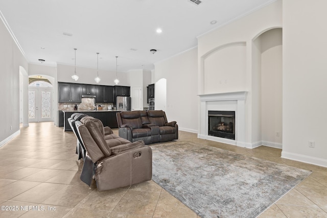 living room featuring arched walkways, light tile patterned floors, a fireplace, and ornamental molding