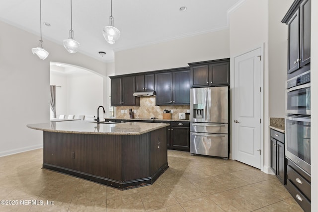 kitchen featuring under cabinet range hood, stainless steel appliances, a sink, decorative backsplash, and crown molding