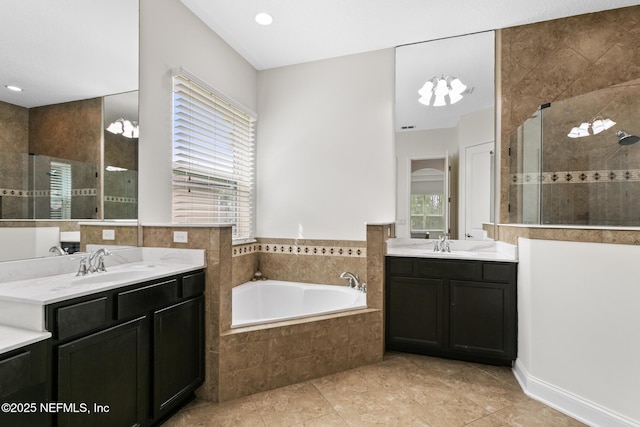 bathroom featuring a garden tub, a tile shower, and a sink