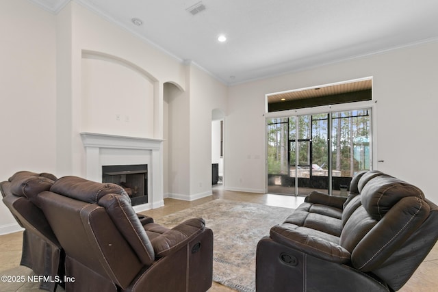 living area with baseboards, a fireplace, visible vents, and crown molding