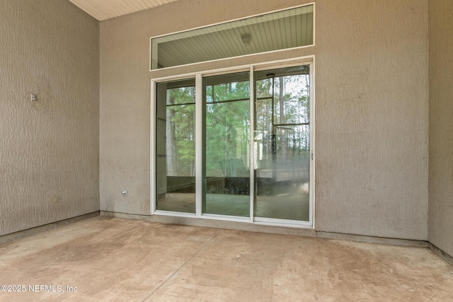 property entrance featuring a patio area and stucco siding