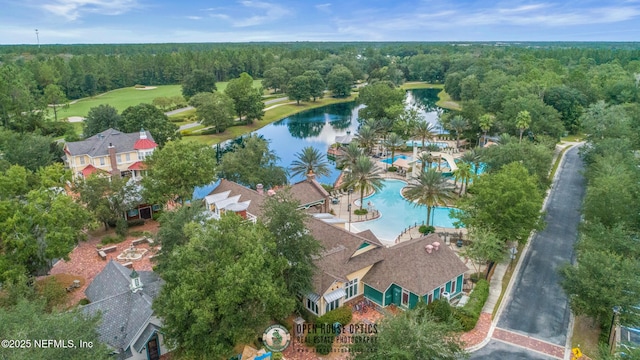 birds eye view of property with a water view and a wooded view