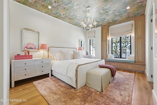 bedroom featuring light wood-type flooring and an inviting chandelier