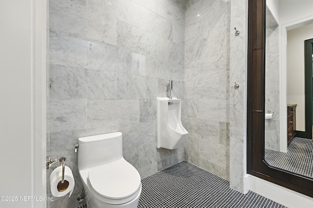 bathroom featuring a tile shower and toilet