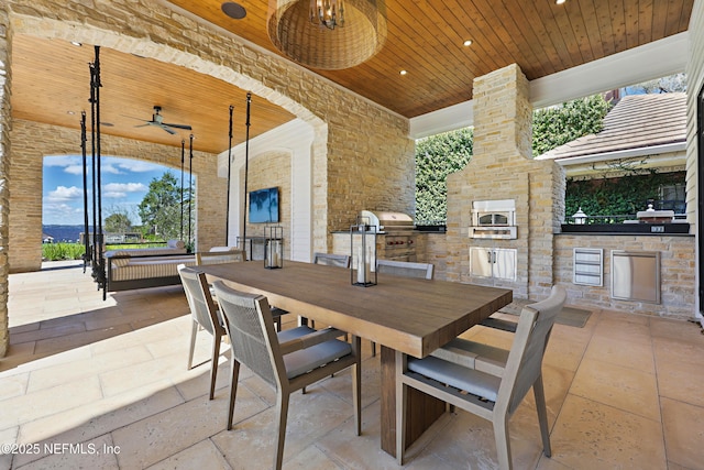 view of patio / terrace with a ceiling fan, outdoor dining area, a grill, and an outdoor kitchen