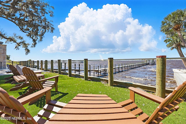 exterior space with a lawn, a water view, and a dock