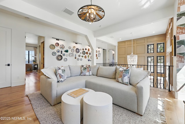 living room featuring a chandelier, visible vents, and light wood-style floors