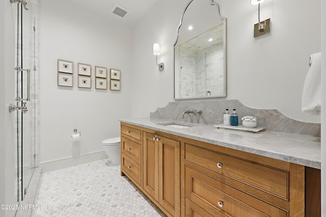 bathroom with toilet, visible vents, vanity, tile patterned floors, and a shower with door